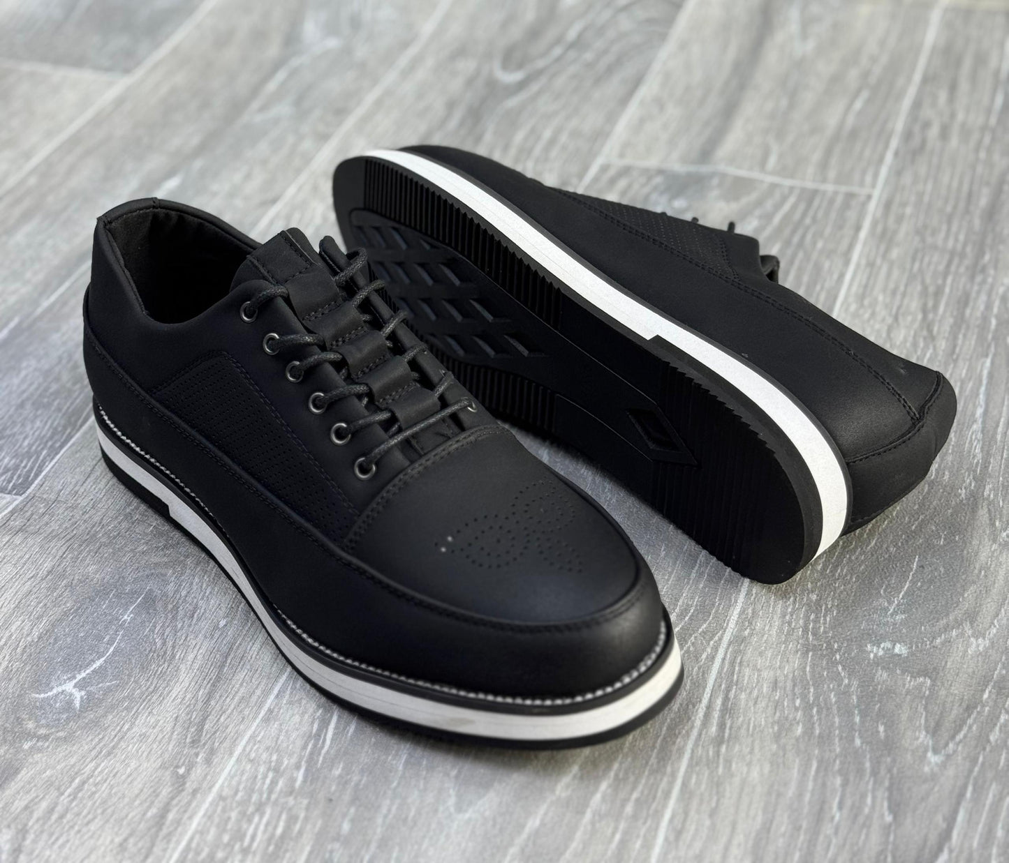 chaussures de ville décontractées noires avec des semelles blanches.
