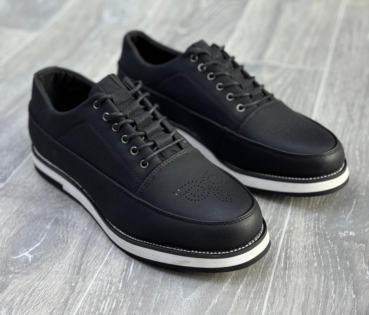 chaussures de ville décontractées noires avec des semelles blanches.
