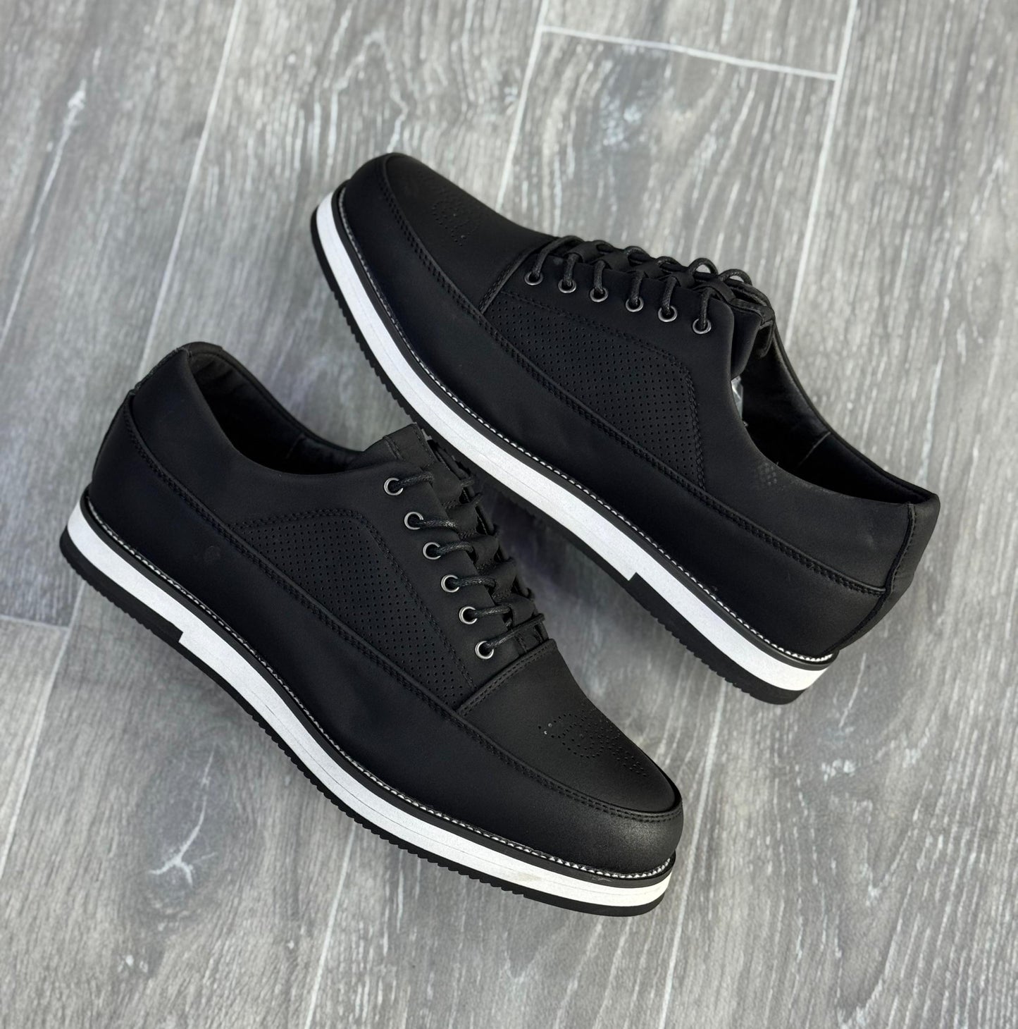 chaussures de ville décontractées noires avec des semelles blanches.